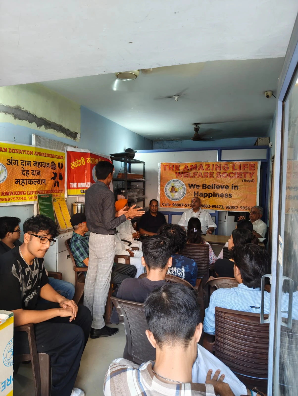 A community awareness meeting beneath campaign banners