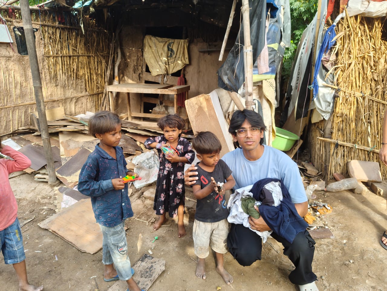 A volunteer with children, sharing donated clothing